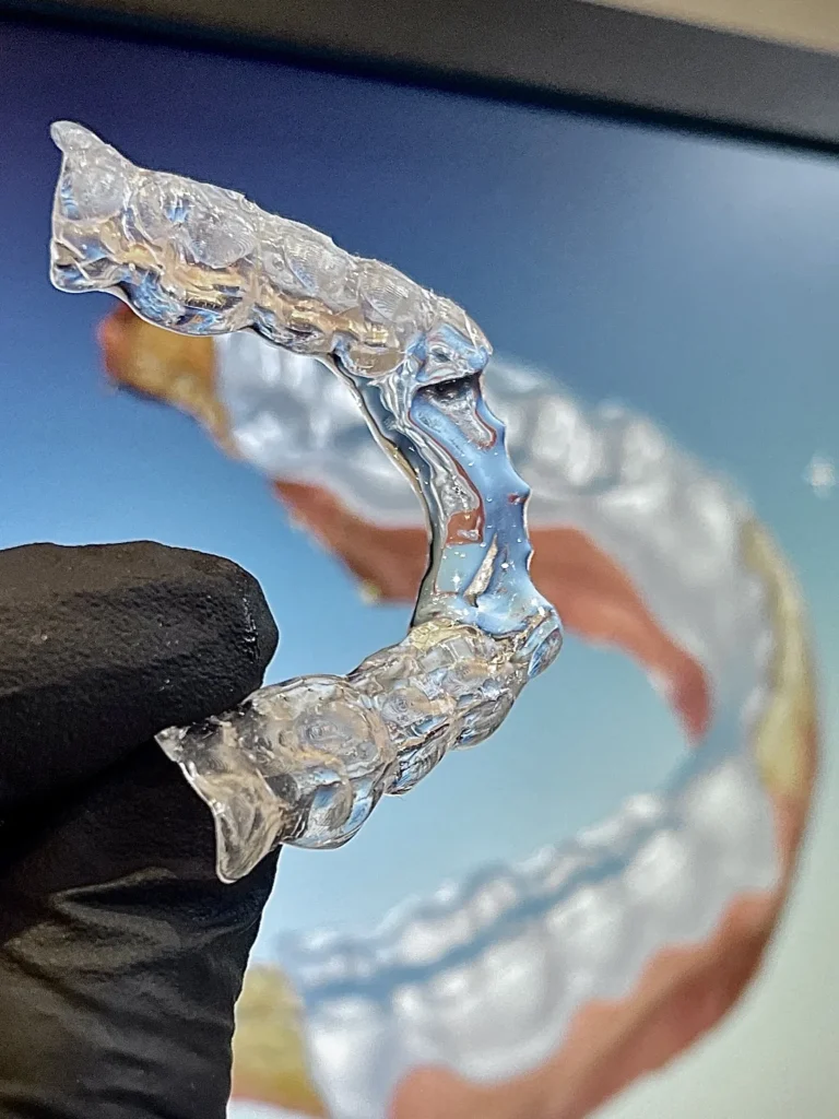 Durchsichtige Schiene in der Hand, dahinter die digitale Konstruktion